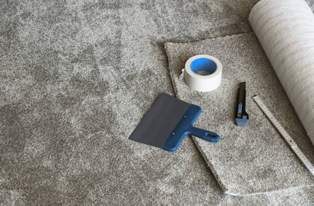 Carpet installation tools and a roll of gray carpet